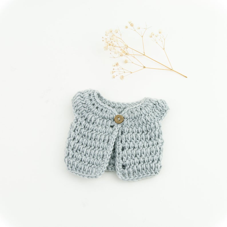 This cosy, textured doll vest is hand knitted in Europe, specially designed for the 38 cm dolls, but can fit dolls around 34 - 40 cm (13 - 15 inch) Miniland, Minikane, Paola Reina Gordis etc, has beautiful details and presents a wooden button at the front to facilitate dressing the doll, just adorable!