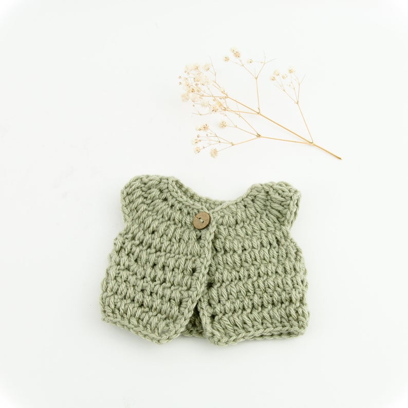 This cosy, textured doll vest is hand knitted in Europe, specially designed for the 38 cm dolls, but can fit dolls around 34 - 40 cm (13 - 15 inch) Miniland, Minikane, Paola Reina Gordis etc, has beautiful details and presents a wooden button at the front to facilitate dressing the doll, just adorable!