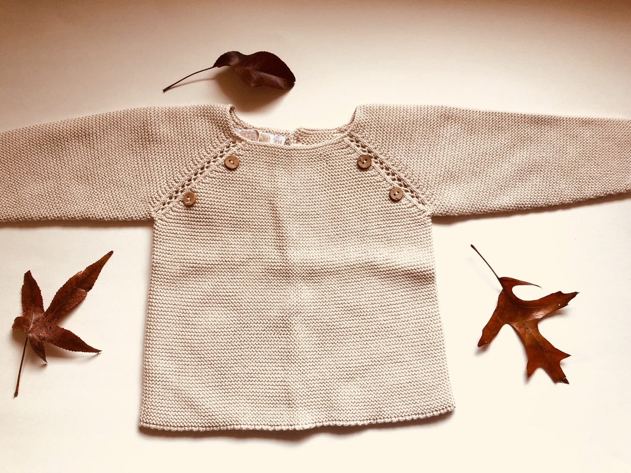 Sweet knitted jumper with wooden buttons in a beautiful beige colour.