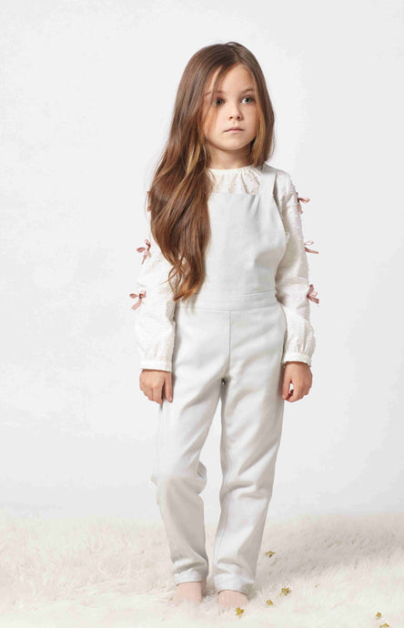 Adorable light grey jumpsuit for  girls with pockets at front. Made with the softest cotton. Straps that cross over at the back and ties with a sweet bow adding character to the garment.