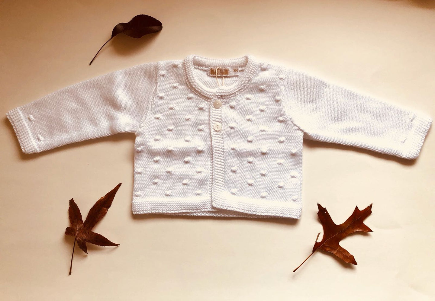 Sweet Unisex Bubble knitted cardigan with wooden buttons in white. I must have basic.