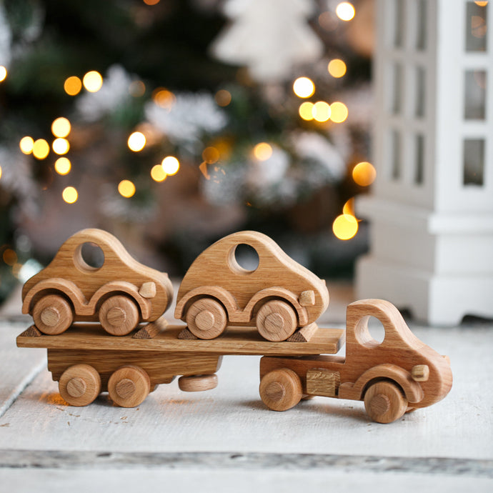Our beautiful Wooden Car Transporter is a well designed  and of solid construction that will last many years. Sturdy truck with 8 wheels ( with a spare one) and a removable trailer. This wooden transporter has a trailer that transports two beautifully made wooden cars which fit neatly on the back of the transporter.